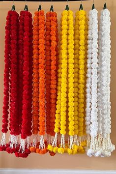 several different colors of pom poms hanging from hooks