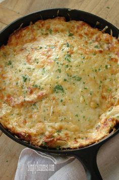 a cheesy casserole in a cast iron skillet on a wooden table