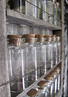 several glass jars are lined up on the wall