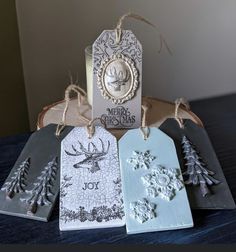 four tags with christmas designs on them sitting on a table