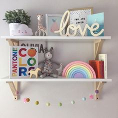 two white shelves with books and toys on them