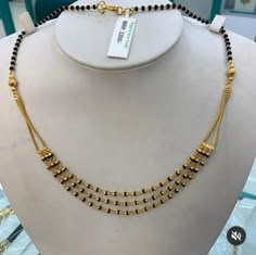 a gold necklace on display in a store