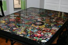 a table covered with lots of stickers and magnets in a room next to a window