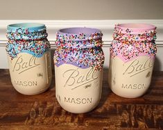 three mason jars with colorful sprinkles on them