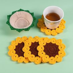 two crocheted coasters and a cup of tea on a green table top