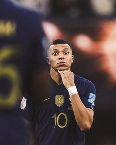 a soccer player is looking up at the sky while holding his hand to his face