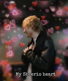 a man standing in front of a wall with lots of hearts on it and the words, my sherrio heart