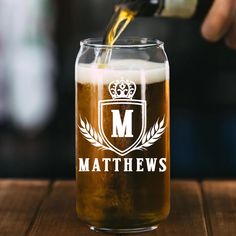 a person pouring beer into a glass on top of a wooden table with the words mathews