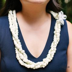 a woman wearing a necklace with white beads