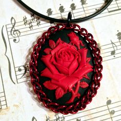 "This stunning resin cameo is wrapped in glossy shiny red chainmail. Measuring approximately 40x30mm, it is beautifully detailed with a red rose in full bloom, with another rosebud beginning to blossom behind.. The perfect addition to the neck of any fancy dress. A 16\" black rubber cord accompanies this beautiful piece, and the chainmail wrap is secured permanently with a bonded layer of epoxy. Find out more about Utopia: https://www.youtube.com/watch?v=LLcsWkbkIEg facebook.com/utopiaarmoury in Gothic Theme, Gothic Themes, Wrist Jewelry, Cameo Jewelry, Gucci Soho Disco Crossbody, Japanese Flowers, Rose Rouge, La Rose, Chain Mail