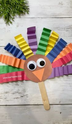 a paper plate turkey with colored strips on it