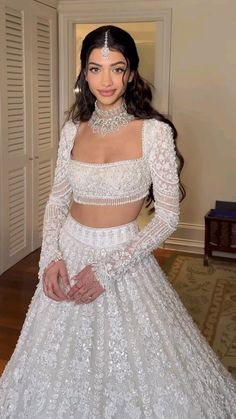 a woman in a white wedding dress posing for the camera