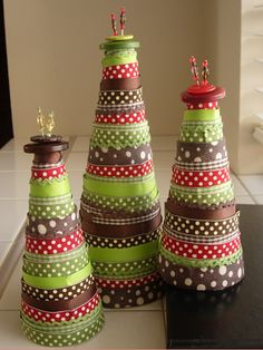 three decorated christmas trees sitting on top of a table