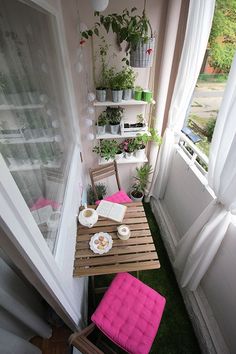 small balcony with table and chairs, potted plants on the window sill next to it