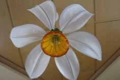 a white and yellow flower hanging from the ceiling