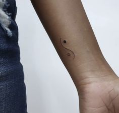 a woman's arm with a small tattoo on it