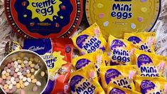 various snacks and candy are laid out on the floor next to each other, including eggs