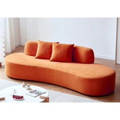 an orange couch sitting on top of a wooden floor