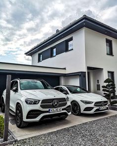 two mercedes benz cars parked in front of a house