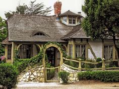 the house is surrounded by hedges and trees