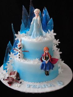 there is a cake that has frosting on it with snowmen and princesses