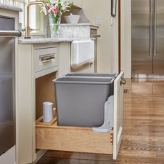 an open trash can in the middle of a kitchen