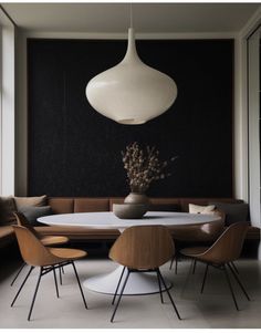 a dining room table with four chairs and a large white light hanging from the ceiling