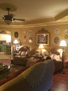 a living room filled with furniture and pictures on the wall