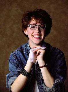 a woman wearing glasses and smiling for the camera