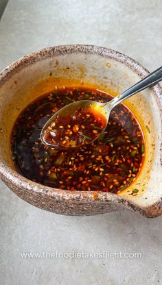 a spoon in a bowl filled with sauce