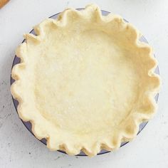 an uncooked pie crust sitting on top of a blue and white plate