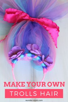 a purple and blue tulle headband with pink flowers on it that says make your own trolls hair