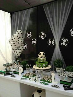 a table topped with lots of green and white cake next to soccer themed desserts