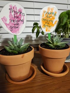 two potted plants with hand prints on them