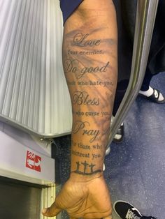 a person with a tattoo on their arm holding onto a luggage bag in an airport