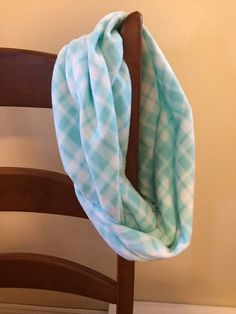 a blue and white checkered blanket sitting on top of a wooden chair