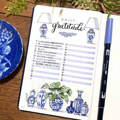 an open notebook on a table next to a blue and white plate