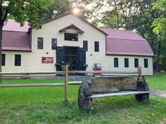 an old wooden bench sitting in front of a white building with red roof and windows