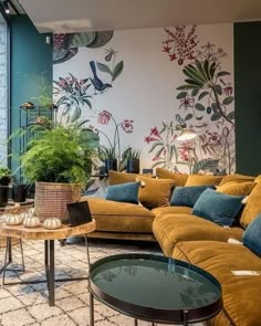 a living room filled with lots of furniture next to a tall wall covered in plants