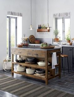 a kitchen island with pots and pans on it in the middle of a room