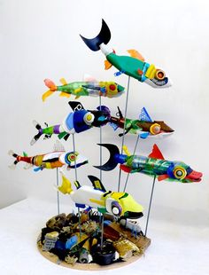 there are many different types of fish on the stand together and one is painted yellow, green, blue, red