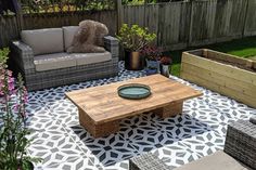 an outdoor living area with couches, tables and potted plants on the ground