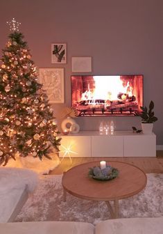 a living room filled with furniture and a christmas tree in front of a fire place