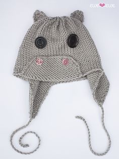 a knitted animal hat with buttons on the front and side, sitting on a white surface