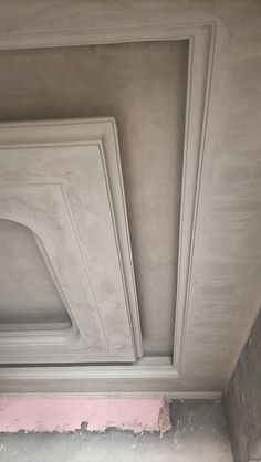 an unfinished ceiling with plaster and pink paint