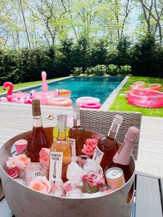 a bucket filled with drinks next to a swimming pool