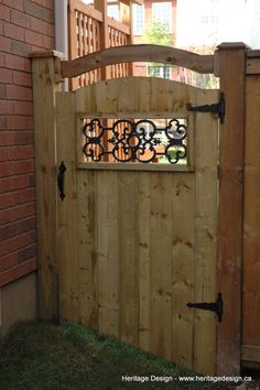 a wooden gate with wrought iron designs on it