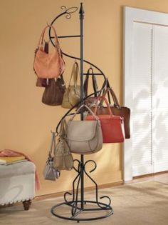 a rack with purses and handbags hanging from it's sides in a bedroom