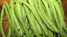 green beans are sitting on a cutting board