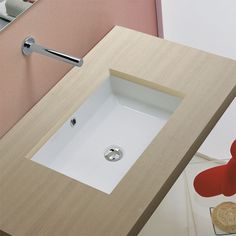 a bathroom sink sitting under a mirror next to a wall